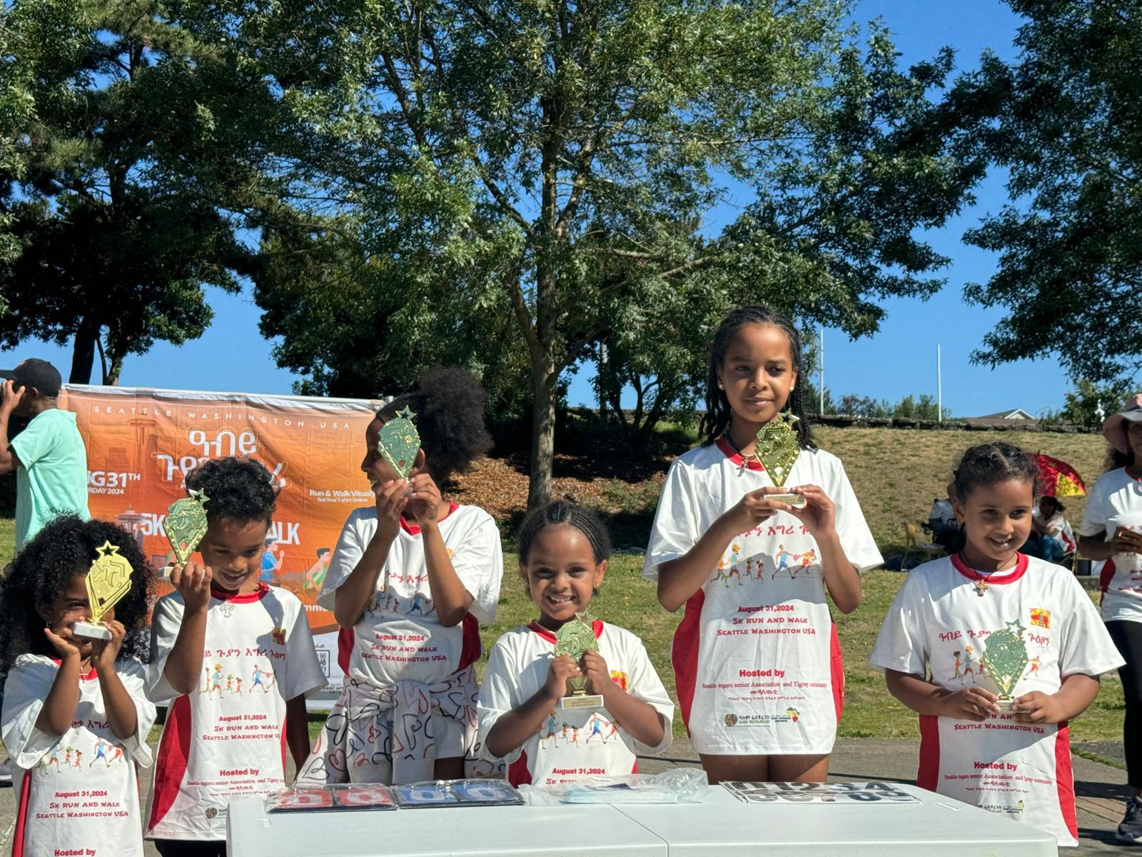 Tigrayan youth holding trophies at the annual 5K run in Seattle